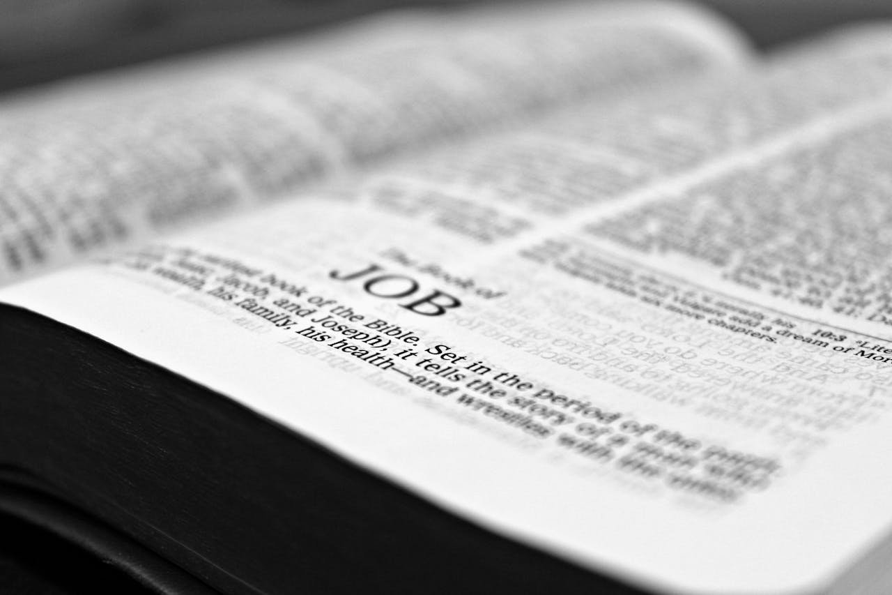 services-02 Close-up black and white image focusing on a Bible page with the Book of Job.